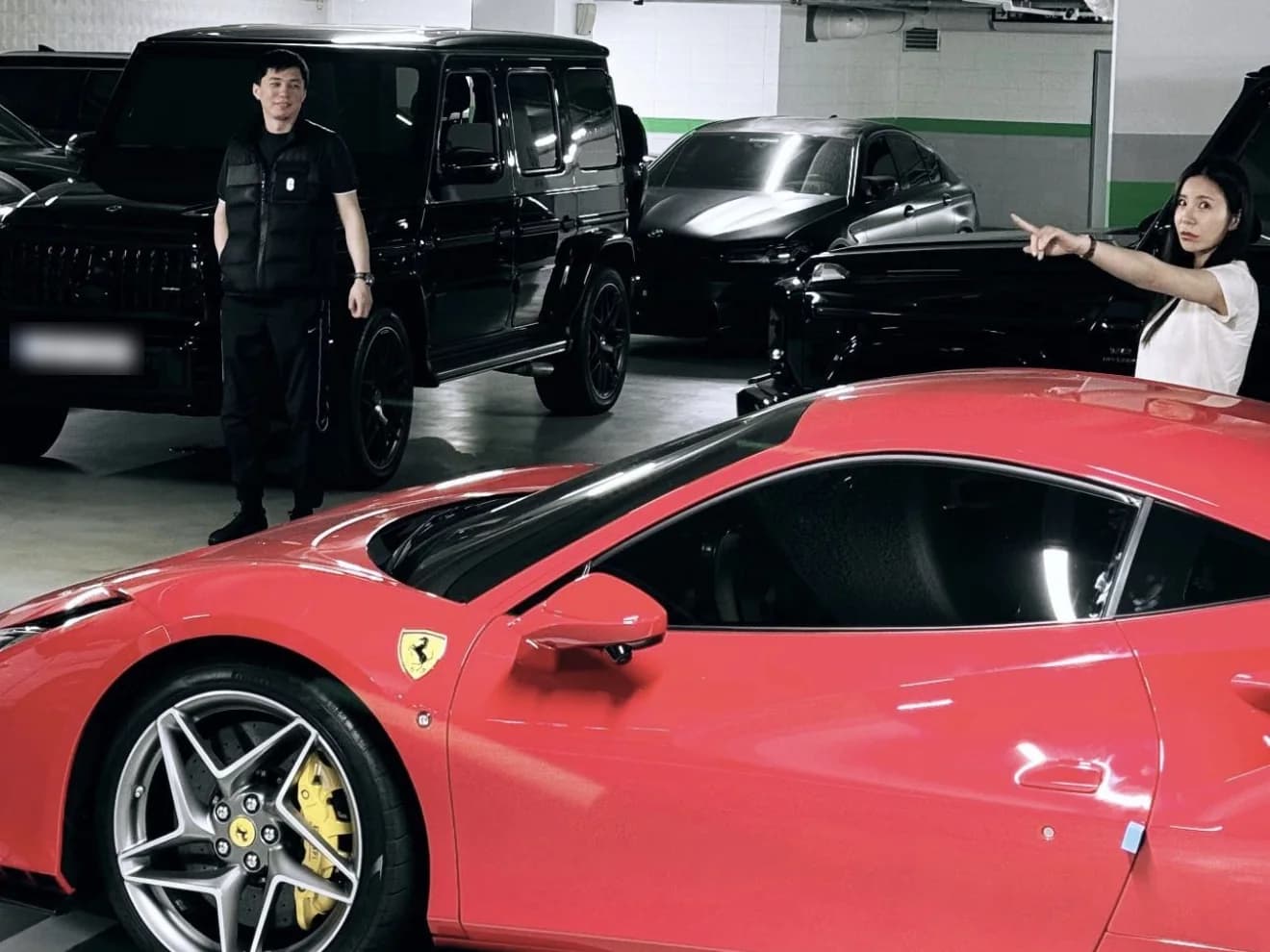 Дархан Абикеев рядом с чёрным Mercedes-AMG G-Class и красной Ferrari